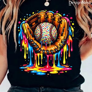 May include: A black t-shirt featuring a colorful graphic of a baseball in a mitt. The baseball is covered in colorful dots, and the mitt and ball are surrounded by dripping paint in shades of yellow, blue, pink, and orange.