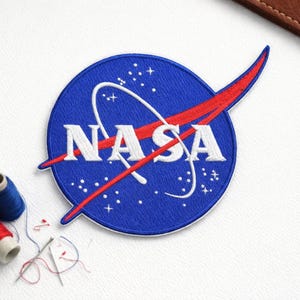 May include: A set of three ceramic mugs with a speckled, matte finish. Each mug features a different color: light blue, cream, and gray. The mugs have a simple, modern design and a comfortable handle. Perfect for coffee or tea.