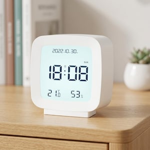 May include: A white square digital clock with rounded corners featuring a light blue screen. The display shows the date 2022.10.30, the time 18:08, the day SUN, a temperature of 21.6 degrees Celsius, and a humidity level of 53 percent.