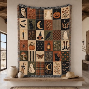 May include: A woven throw blanket featuring a grid of rectangular panels with autumn and Halloween imagery, including owls, pumpkins, ghosts, black cats, bats, moths, moons, witches' hats, lanterns, and floral patterns with fringed edges.