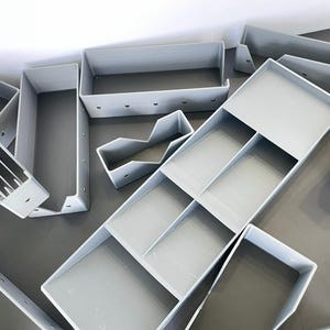 May include: A white ceramic mug with a black handle and the text "But First, Coffee" in a handwritten style. The mug is on a white surface. The mug is 4 inches tall.