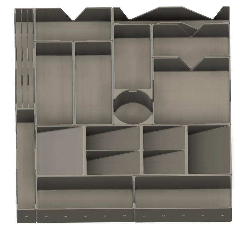 May include: A gray plastic organizer with multiple compartments of varying sizes and shapes. The organizer includes rectangular, square, and circular sections, designed for storing small items. The overall design is modular and functional.