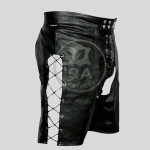 Puede incluir: Shorts de cuero negro con detalles de cordones en los laterales. Los shorts tienen una cintura alta y están tachonados en la cintura. Los shorts tienen cortes en los laterales.