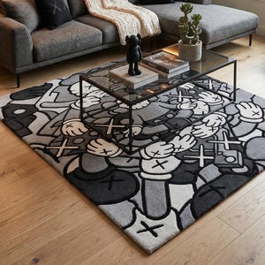 May include: A rectangular area rug featuring a repeating grayscale graphic pattern of cartoon-style gloved hands and cross-shaped eyes. The rug is positioned under a rectangular glass-top coffee table with a black metal frame in a living room.