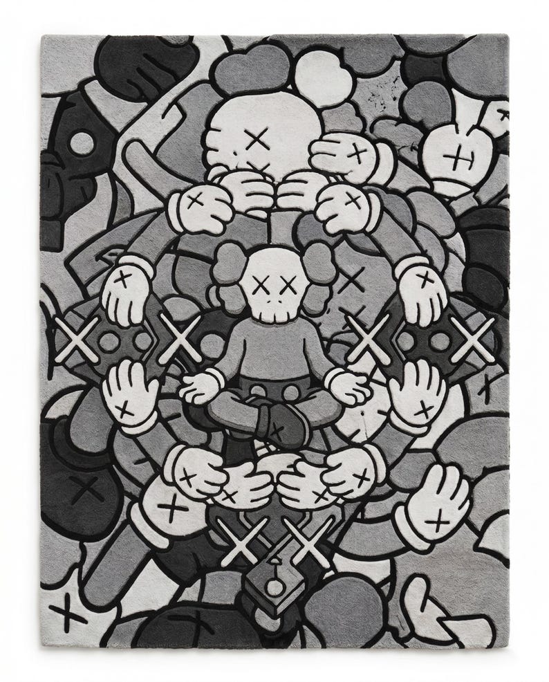 May include: A rectangular rug featuring a grayscale graphic illustration of multiple cartoon-style figures with X-shaped eyes. A central figure sits in a cross-legged position, surrounded by a circular arrangement of hands and additional character heads.