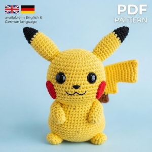 May include: A yellow crocheted plush toy featuring two long ears with black tips, red circular cheeks, large black plastic eyes, a small black nose, and a lightning bolt-shaped tail. The text PDF PATTERN is visible in the upper right corner.