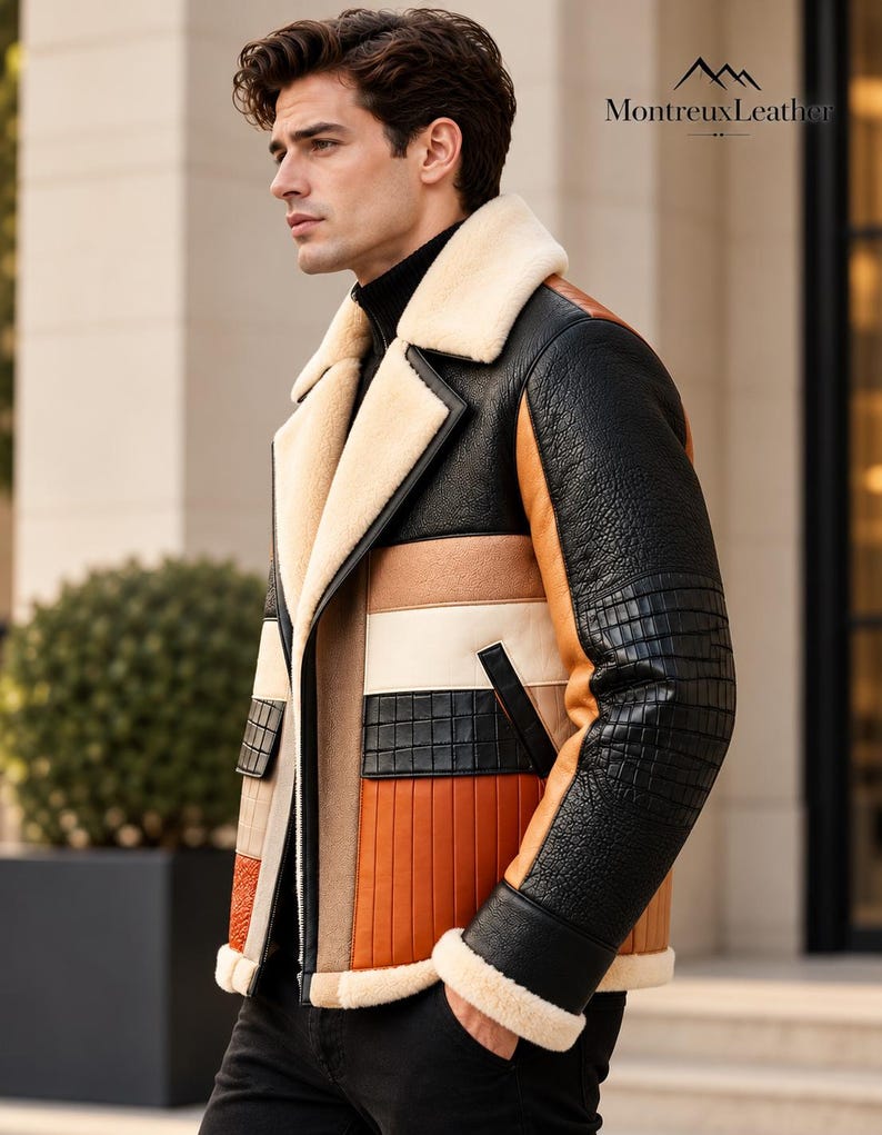 Puede incluir: Una chaqueta de cuero con bloques de color en tonos negro, tostado y naranja con acabado texturizado. La prenda incluye cuello y pu&ntilde;os de borrego color crema, cierre de cremallera frontal y el texto MontreuxLeather en la esquina superior.