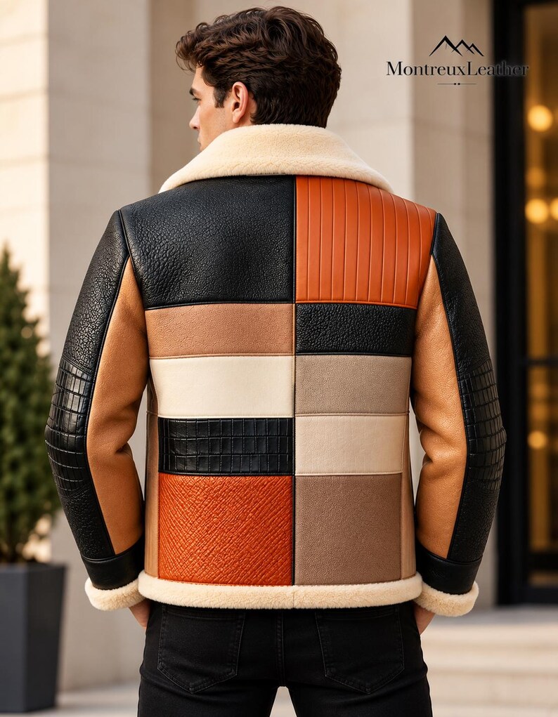 Puede incluir: Una chaqueta de bloques de color con cuello y dobladillo de piel de oveja color crema. El panel trasero muestra un dise&ntilde;o de patchwork de texturas de cuero negro, tostado, beige y naranja. Las mangas son negras con detalles tostados. Texto MontreuxLeather.