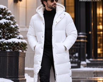 May include: A long white puffer coat featuring a hood with a light-coloured lining, a front zip closure, and metal snap buttons. The coat has horizontal quilted sections and long sleeves. The text MontreuxLeather is visible in the top right corner.