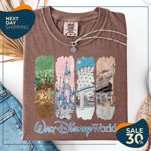 a brown t-shirt with a collage of four Disney World-themed illustrations, including a castle, a tree, a building, and a hotel. The t-shirt is displayed on a white background, and there are two sale signs indicating a 30% discount.