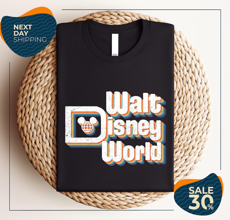 A black t-shirt with the text "Walt Disney World" printed on it, along with a Mickey Mouse logo. The t-shirt is displayed on a woven placemat, and there are two sale signs indicating a 30% discount on the item.