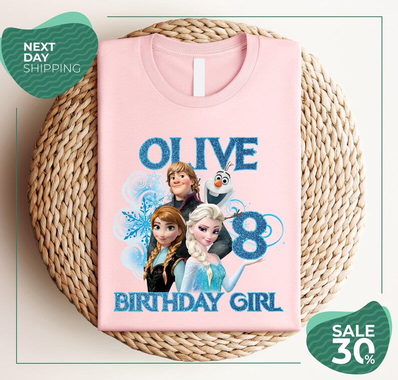 A pink t-shirt with a graphic design featuring characters from the Disney movie Frozen, specifically Olive, and the text "OLIVE 8 BIRTHDAY GIRL".