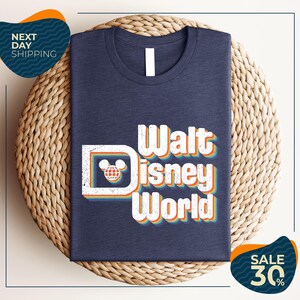 A dark blue t-shirt with the text "Walt Disney World" printed on it, placed on a woven basket.