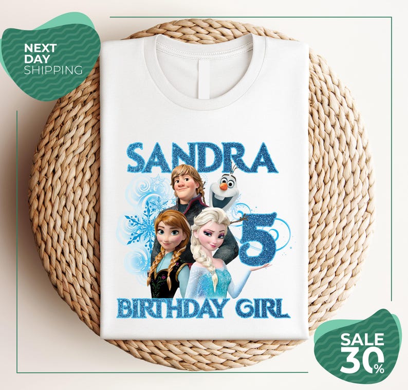 A white t-shirt with a design featuring characters from the Disney movie Frozen, specifically Elsa, Olaf, and Anna, along with the text "SANDRA BIRTHDAY GIRL".