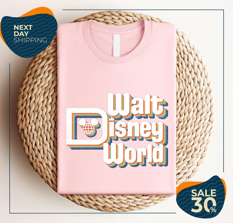 A pink t-shirt with the text "Walt Disney World" printed on it, placed on a woven basket.
