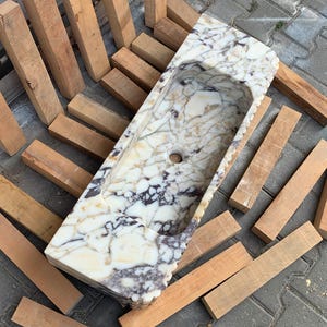 Find your perfect bathroom marble sink with our extensive range of vessel sinks, wallmount sinks, and trough sinks. Featuring luxury stones like viola marble and calcutta marble, our sinks create breathtaking focal points. Elegant marble kitchen sinks, utility sinks, and workstation sinks available in custom designs. Turkish marble craftsmanship at its best. Transform your space with a marble wall sink or marble countertop sink. Featuring calacatta marble, travertine, and italian marble sinks.