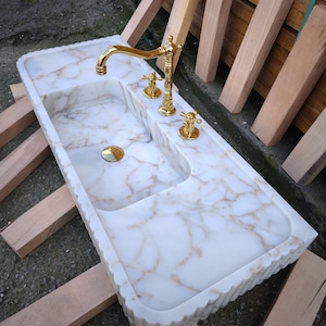 Find your perfect bathroom marble sink with our extensive range of vessel sinks, wallmount sinks, and trough sinks. Featuring luxury stones like viola marble and calcutta marble, our sinks create breathtaking focal points. Elegant marble kitchen sinks, utility sinks, and workstation sinks available in custom designs. Turkish marble craftsmanship at its best. Transform your space with a marble wall sink or marble countertop sink. Featuring calacatta marble, travertine, and italian marble sinks.