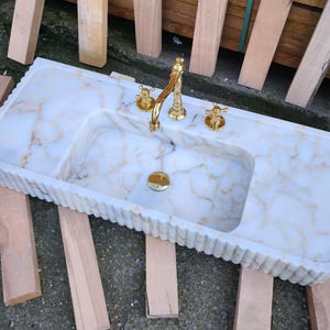 Explore the beauty of a calacatta viola marble sink or a carerra marble sink in your luxury project. Whether you need a pedistal sink, console sink, or laundry sink, our handcrafted natural marble sinks bring timeless elegance. Upgrade your vanity with a marble sink top or marble basin sink. beautiful calacatta, lilac, and carrara marble options. Luxury marble sinks for every space: bathroom, kitchen, laundry. Explore wall mount marble sinks, vessel sinks, and integrated marble sinks.