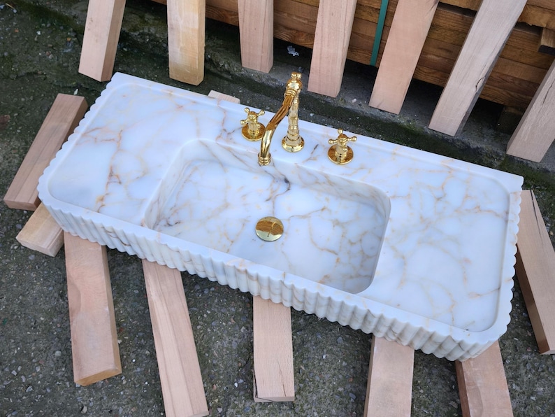 Explore the beauty of a calacatta viola marble sink or a carerra marble sink in your luxury project. Whether you need a pedistal sink, console sink, or laundry sink, our handcrafted natural marble sinks bring timeless elegance. Upgrade your vanity with a marble sink top or marble basin sink. beautiful calacatta, lilac, and carrara marble options. Luxury marble sinks for every space: bathroom, kitchen, laundry. Explore wall mount marble sinks, vessel sinks, and integrated marble sinks.