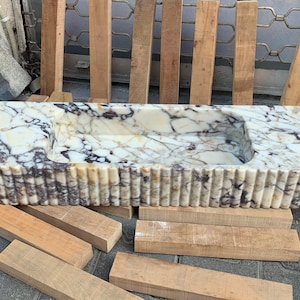 Looking for a unique marble sink? Our marble vessel sinks and marble countertop sinks are sculpted from premium stones like arabescato marble and calacatta gold marble. Add elegance to your bathroom with a true piece of art. Discover luxury marble vessel sinks, floating sinks, and integrated sinks. Perfect for elegant bathroom and kitchen upgrades. Custom orders available! Handmade marble sinks: calacatta sink, viola sink, carrara sink. Wall mounted, floating, and farmhouse marble sink designs.