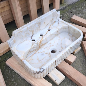 Explore the beauty of a calacatta viola marble sink or a carerra marble sink in your luxury project. Whether you need a pedistal sink, console sink, or laundry sink, our handcrafted natural marble sinks bring timeless elegance. Upgrade your vanity with a marble sink top or marble basin sink. beautiful calacatta, lilac, and carrara marble options. Luxury marble sinks for every space: bathroom, kitchen, laundry. Explore wall mount marble sinks, vessel sinks, and integrated marble sinks.
