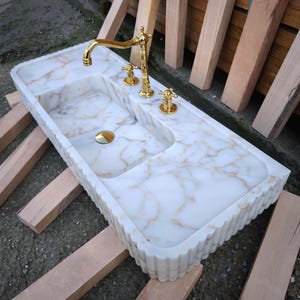 Bring antique charm to your home with our antique marble sinks and marble sink consoles. Each marble sink antique piece is a tribute to classic craftsmanship, blending history with the enduring beauty of stone marble sinks. Shop fluted marble sinks, ribbed marble sinks, marble vessel sinks. Handmade from the finest natural marbles for stunning home designs. Handcrafted marble sinks from Turkey. marble basin sinks, vanity sinks, and custom sink tops in beautiful natural stones like viola marble.