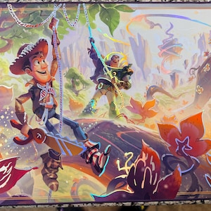 May include: A rectangular playmat featuring a vibrant illustration of characters from the Disney Lorcana Trading Card Game. The artwork depicts Woody and Buzz Lightyear in a colorful forest setting, with the game's logo in the lower right corner.
