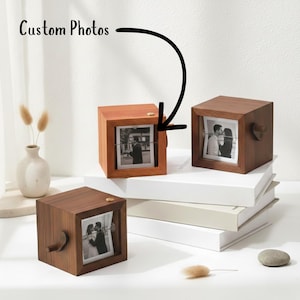May include: Dark wood photo cubes displaying custom photos. Each cube has a square shape, a dark wood finish, and a small wooden knob. The photos are held by a wire. The image includes the text "Custom Photos".