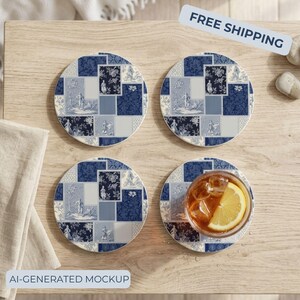 May include: Four circular coasters featuring a blue and white patchwork toile pattern with various scenes and floral motifs. One coaster supports a clear glass filled with an amber liquid and a slice of lemon, showcasing the coaster's functional use.