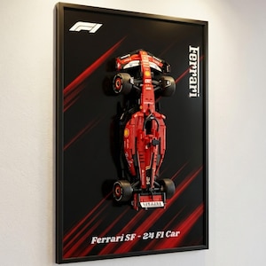 Peut inclure: Œuvre encadrée représentant une maquette rouge d'une Ferrari SF-24 F1 sur fond noir avec des traits rouges. Le logo et le texte Ferrari sont visibles. Le cadre est noir.