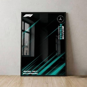 Puede incluir: Póster enmarcado en negro con el logotipo y la marca Mercedes-AMG Petronas Formula 1 Team. El diseño presenta líneas diagonales turquesas sobre un fondo negro. El texto "MERCEDES - AMG F1 W14 E PERFORMANCE" es visible en la parte inferior.
