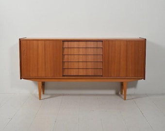 Aparador de teca restaurado con cajones corredizos y patas cónicas.