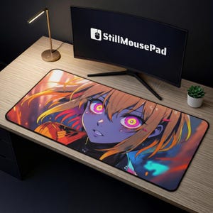 May include: A rectangular mouse mat with a colourful anime-style illustration of a female character with orange hair and purple skin. The character has large eyes with pink and yellow irises. The mouse mat has the text "StillMousePad" on the monitor.