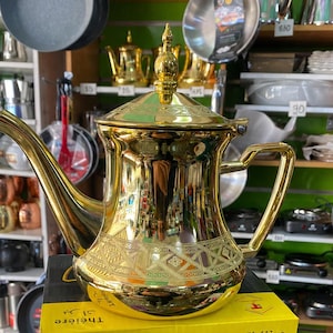 Tetera tradicional marroquí de metal dorado: elegante y duradera para el té.