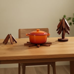 May include: A white ceramic mug with a black handle and the text "But First, Coffee" in a bold, black font. The mug is set against a blurred background, suggesting a cozy setting.