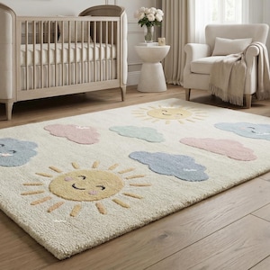 Könnte beinhalten: Cremefarbener Kinderzimmerteppich mit einem verspielten Design aus lächelnden Sonnen und pastellfarbenen Wolken. Der rechteckige Teppich liegt auf einem Holzboden und schafft einen weichen und einladenden Raum für ein Babyzimmer.