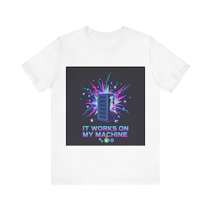Może przedstawiać: Biała koszulka z graficznym wzorem przedstawiającym ilustrację serwera. Projekt zawiera tekst "IT WORKS ON MY MACHINE" w kolorowej czcionce, a także klucz, koło zębate i filiżankę kawy.