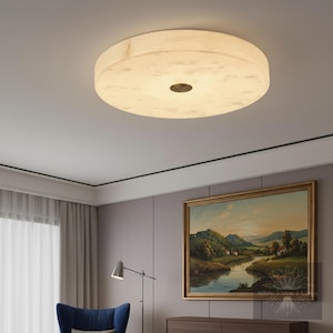 May include: A white ceramic mug with a black handle and the text "But First, Coffee" in a bold, black font. The mug is set against a blurred background, suggesting a cozy setting.