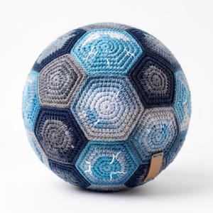 Puede incluir: Balón de fútbol hecho a mano con hilo de ganchillo. El balón presenta un diseño de retazos de paneles hexagonales azules, grises y blancos. Tiene una etiqueta de cuero adjunta. Un artículo decorativo único.