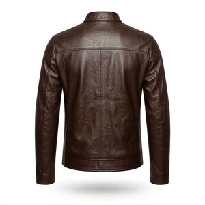 May include: A brown leather jacket with a stand-up collar. The back view of the jacket shows vertical stitching details and a tailored fit. The jacket has long sleeves and a classic design.