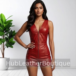 May include: A sleeveless red leather romper featuring a deep V-neckline and a full-length front zipper closure. The garment is fitted with vertical seam detailing along the bodice and shorts. The text HubLeatherBoutique is visible.
