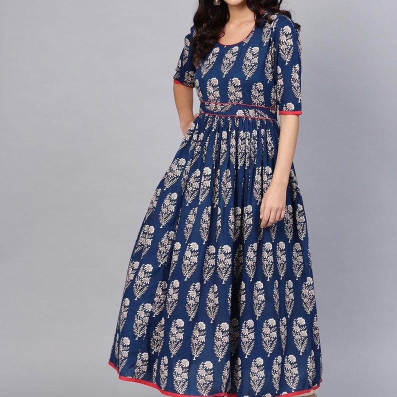 May include: A navy blue maxi dress with a white floral pattern. The dress features short sleeves, a round neckline, and a red trim along the neckline, sleeves, and hem. The waist is cinched with a red band.