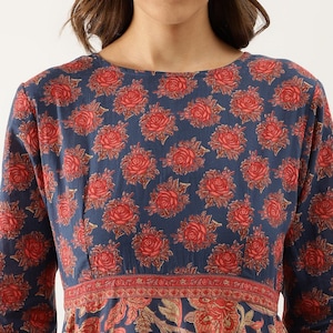 Puede incluir: Vestido de manga larga con fondo azul marino y un estampado repetido de rosas rojas. El vestido tiene un corpi&ntilde;o ajustado y un estampado floral rojo y beige en la cintura y la falda.
