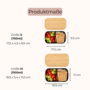 May include: Two rectangular lunch boxes with bamboo lids and black containers, shown in size S (700ml, 17.5 x 4.5 x 9.5 cm) and size M (1100ml, 18.5 x 5.4 x 11.0 cm). The containers are filled with grapes, tomatoes, and bread slices. Text: Produktma&szlig;e.