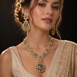 May include: A gold-toned necklace and matching drop earrings set featuring floral-shaped settings with embedded round and heart-shaped multicolored gemstones in shades of pink, green, blue, and red, accented with small clear crystals throughout.