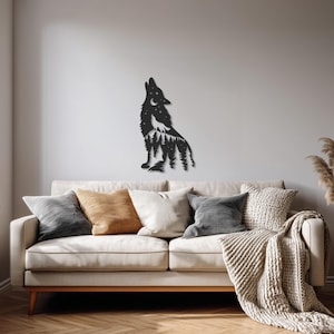 May include: A black metal wall art piece depicting a howling wolf silhouette against a forest and starry night scene. The artwork is mounted on a light gray wall above a beige sofa with various throw pillows and a blanket.