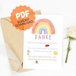 Könnte beinhalten: Eine Aquarell-Regenbogen-Dankeskarte mit dem deutschen Wort "Danke" und anderem Text. Die Karte wird von einem Kraftpapierumschlag und einer weißen Rose begleitet. Ein orangefarbener Aufkleber mit "PDF SOFORT DOWNLOAD" ist angebracht.