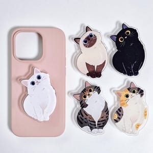May include: A pink phone case with a white cat sticker attached, alongside four additional cat stickers. The stickers feature various cat breeds in different colors, including black, white, and tabby patterns. The stickers are designed to be applied to a phone or other surfaces.