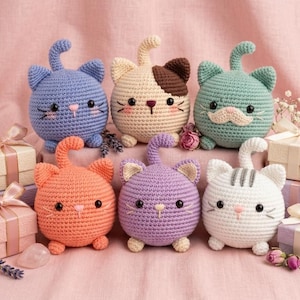 Peut inclure: Six peluches de chat crochetées et rondes de différentes couleurs, dont bleu, crème avec marron, vert, orange, violet et blanc avec des rayures grises. Chaque chat possède de petites oreilles, une queue recourbée, des yeux en perles noires.