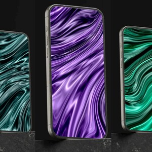 Könnte beinhalten: Drei Smartphones mit silbernen Metallrahmen, die abstrakte, fließende Muster zeigen. Die Bildschirme zeigen wirbelnde Designs in Türkis, Lila und Grün, was eine moderne Ästhetik erzeugt. Die Telefone stehen auf einer dunklen Oberfläche.